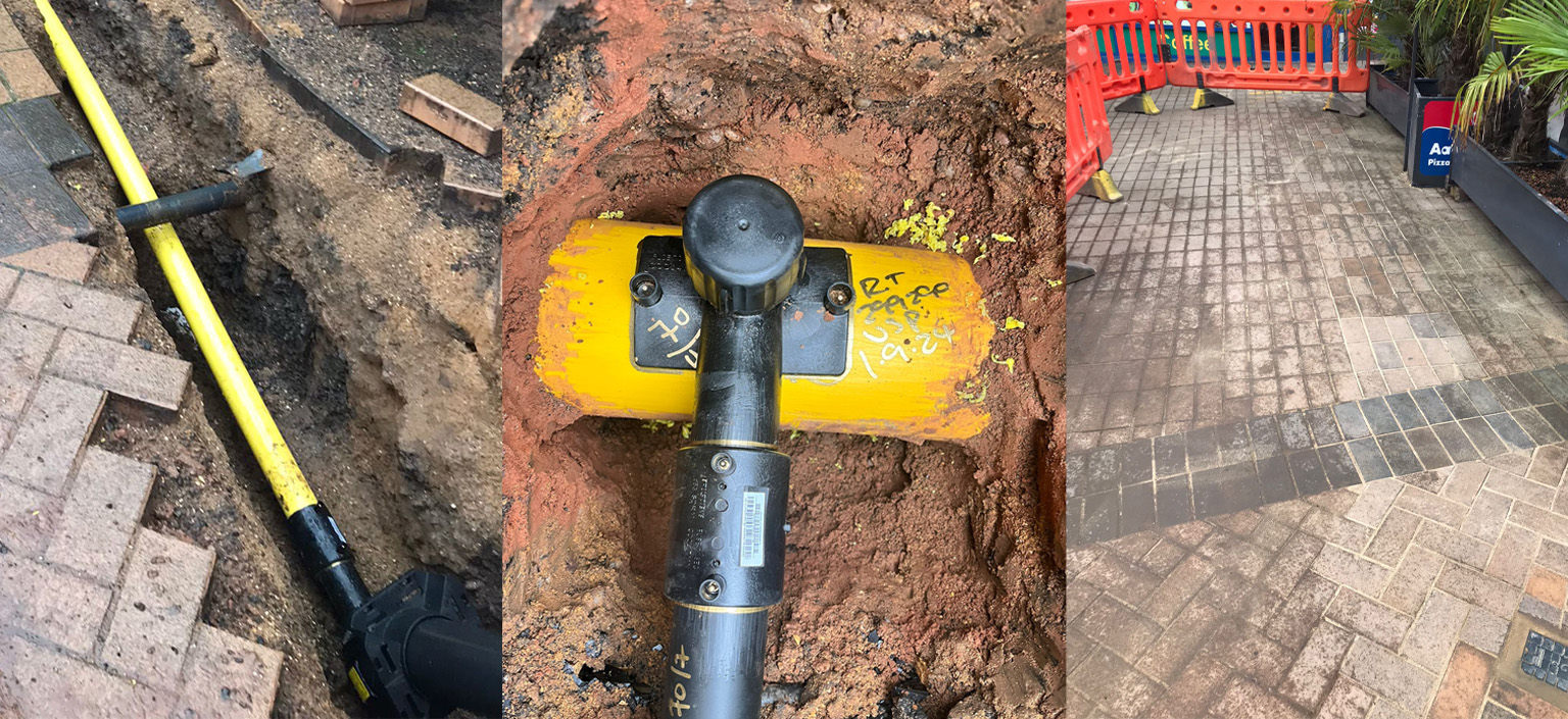 USP team installing gas mains in an open trench with safety barriers on a live development site